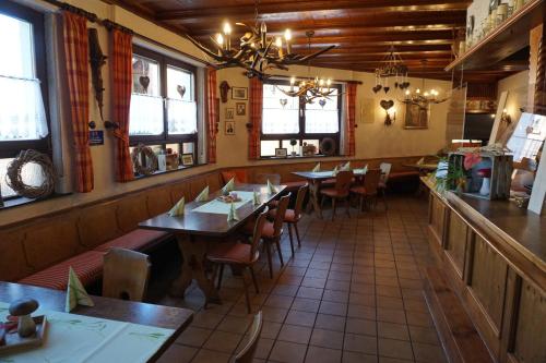 梅斯佩尔布伦Gasthof Zum Löwen的餐厅设有木桌、椅子和窗户。