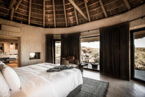 OndekarembaZannier Hotels Omaanda的一间带一张大床的卧室,位于带窗户的房间内