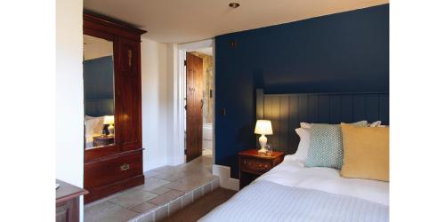 锡德茅斯蓝球旅馆的一间卧室设有蓝色墙和一张床