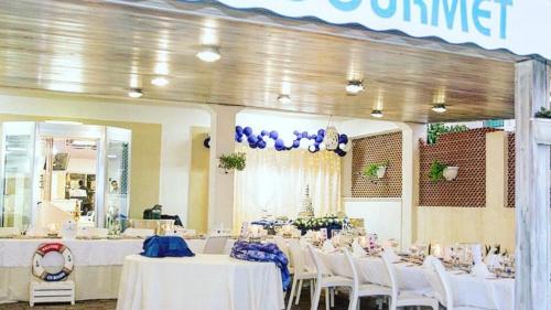 锡代诺滨海Petit gourmet的宴会厅配有白色的桌子和白色的椅子
