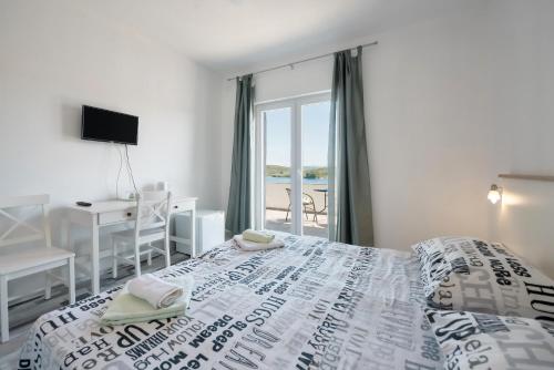 Luka皮奇奇酒店的一间卧室配有一张床、一张书桌和一个窗户。