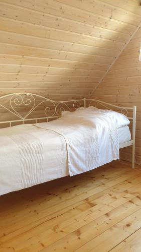 科帕利诺Zakątek Wenantego的卧室配有一张白色的木墙床