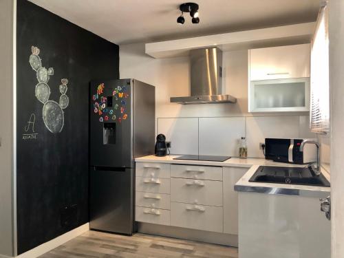 拉斯内格拉斯Apartamento Algazul的厨房配有黑冰箱和白色橱柜。