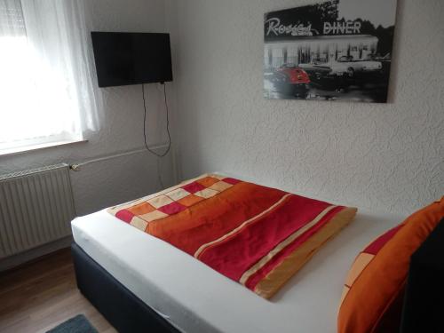 VeitsbronnGästezimmer Boxenstopp的一间卧室配有一张带彩色毯子的床
