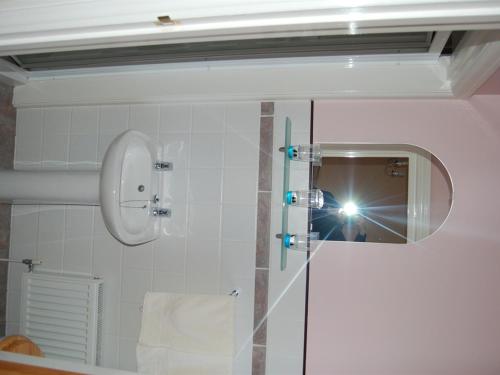 以撒港路端酒店的把淋浴的照片和镜子拍成的人
