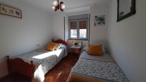 BarciaCASA LA REVERENDA的小房间设有两张床和窗户