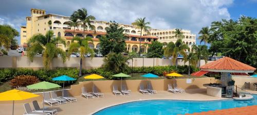 乌马考Park Royal Homestay Club Cala Puerto Rico的一个带游泳池、椅子和遮阳伞的度假村