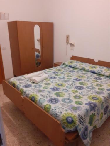 里米尼HOTEL ROSSINI的一间卧室配有一张带花卉棉被的床