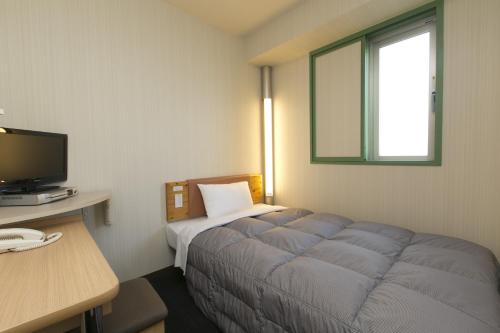 名古屋R&B Hotel Nagoya Nishiki - Vacation STAY 37481v的客房设有床、书桌和电视。