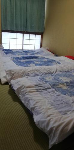 秩父市Suijin Hotel - Vacation STAY 38314v的卧室内的一张未铺好的床,设有窗户