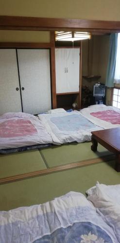 秩父市Suijin Hotel - Vacation STAY 38314v的客房设有三张床和一张木桌