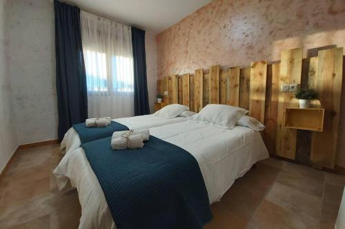 塞哥维亚La Morada de los Olmos的一间卧室配有一张大床和两条毛巾