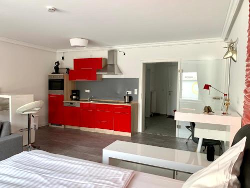 汉诺威Apartment Martinstraße 7b的厨房以及带红色橱柜的起居室。