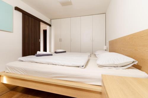 博兹达尔Boží Apartmány V的一间卧室配有一张带白色床单的大床