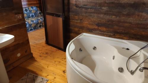 佩达拉Etna Rural Cottage with Jacuzzi的浴室配有白色浴缸及水槽