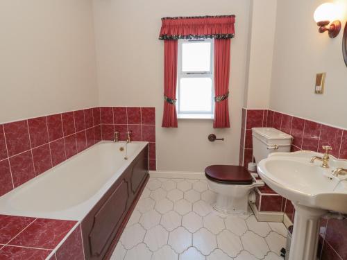 伍勒Cherryburn Cottage的带浴缸、卫生间和盥洗盆的浴室