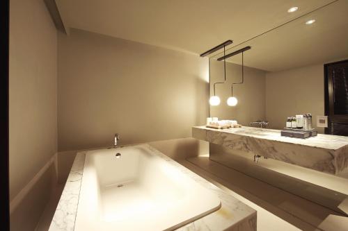 华城市JS经典酒店的带浴缸和盥洗盆的大浴室