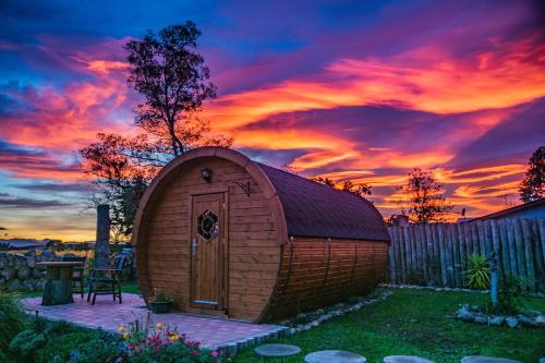 布伦海姆Marlborough Wine Barrel Cabins的小棚子,背面有日落