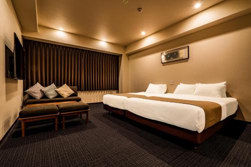 京都Randor Residential Hotel Kyoto Suites的酒店客房设有一张大床和一张沙发。
