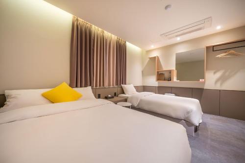 春川Chuncheon Bom Stay的酒店客房,设有两张床和镜子
