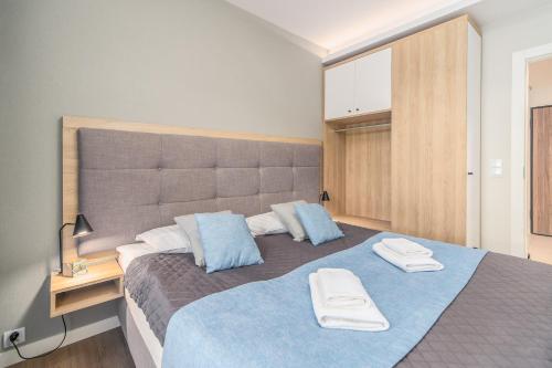 米兹多洛杰Bel Mare Resort Apartment with Parking by Renters的一间卧室配有一张大床和两条毛巾