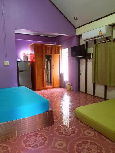 Ban Pak Namบ้านสุขกมลแววดาวบ้านเดี่ยว1ห้องนอน的一间拥有紫色和绿色墙壁的客房和一间厨房