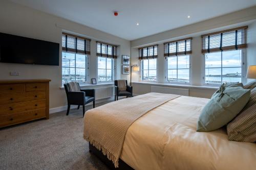 安斯特拉瑟水滨旅舍的一间卧室配有一张大床、书桌和窗户