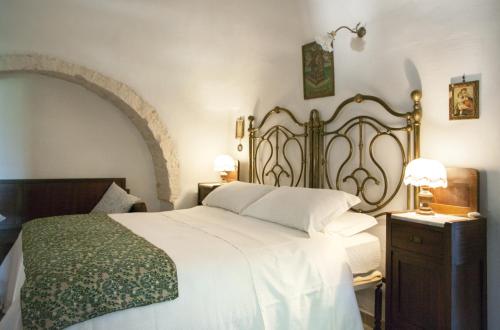 马丁纳弗兰卡Trulli sul vignale in Masseria Santalachicca的卧室配有一张白色大床和两盏灯。