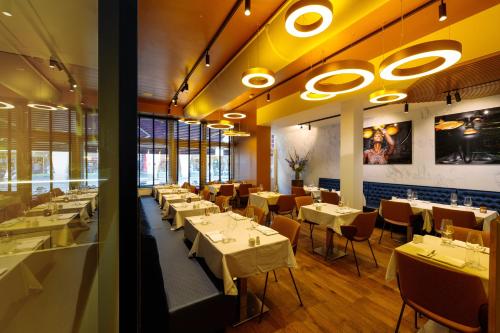 阿姆斯特丹阿不思阿姆斯特丹市中心酒店的一间设有白色桌椅的用餐室