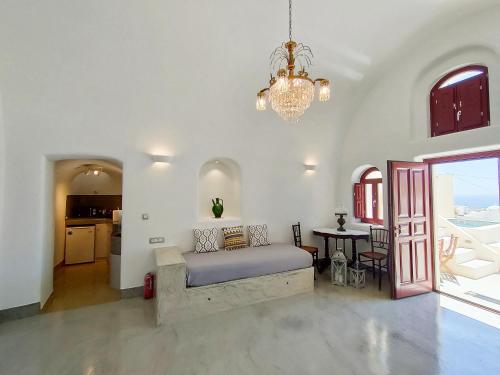 安坡里奥圣托里尼Dreamer's secret villa的一间卧室配有一张床、一张桌子和一个吊灯。