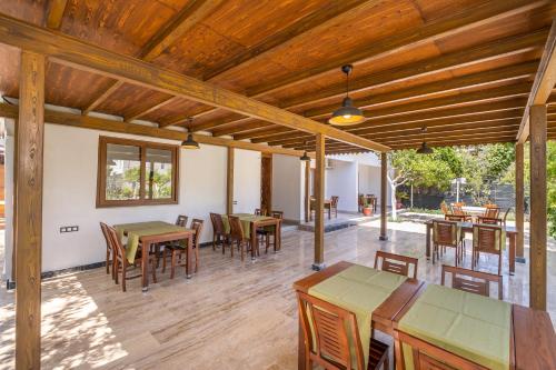 契拉勒Ayris Hotel Çıralı的户外庭院设有木制天花板和桌椅。