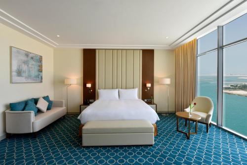 麦纳麦Grand Swiss-Belhotel Waterfront Seef的酒店客房,配有床和沙发