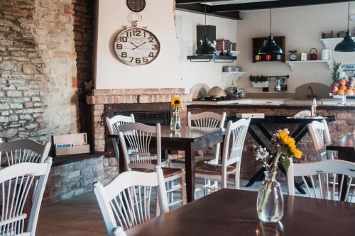 Albaretto Della Torre 拉罗拉旅馆的一间带桌椅和时钟的用餐室