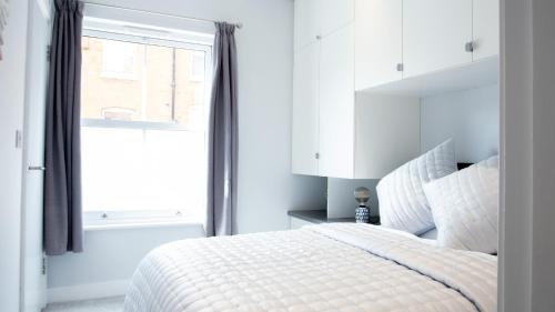 埃文河畔斯特拉特福Modern Apartment with FREE Parking, WIFI and Netflix的白色的卧室设有床和窗户