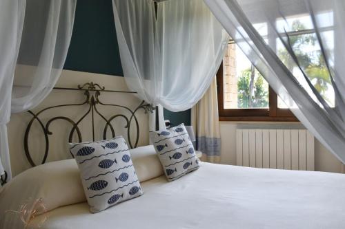 福特村Villa Palmetto的卧室配有带枕头的白色床和窗户。
