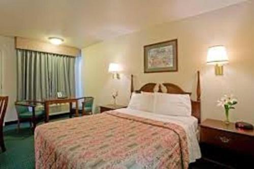 Wellsville百思特汽车旅馆的酒店客房带一张床、一张桌子和椅子