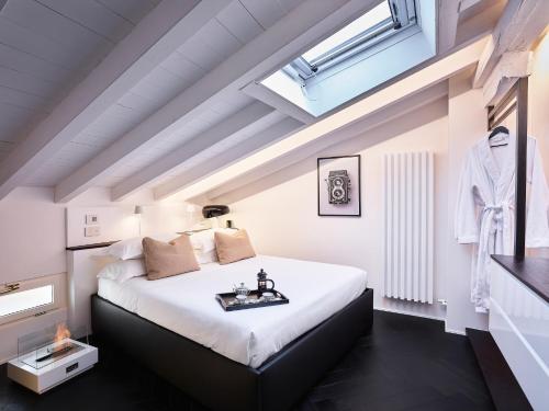 博洛尼亚OBERDAN SUITE Appartamento nel cuore di Bologna的卧室配有一张白色大床和天窗