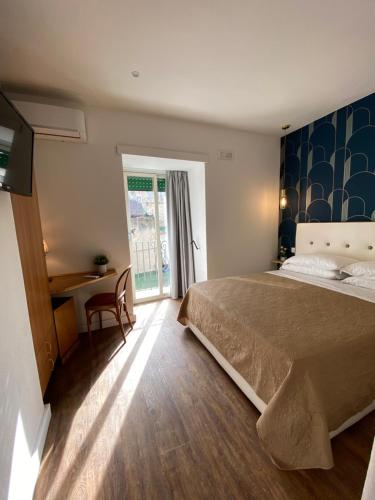 那不勒斯那不勒斯欧洲酒店的一间卧室配有一张床、一张书桌和一个窗户。