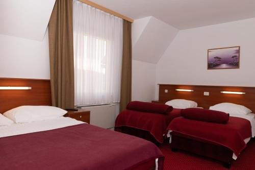 奥托查茨米尔尼库塔克酒店的酒店客房,配有两张带红色床单的床