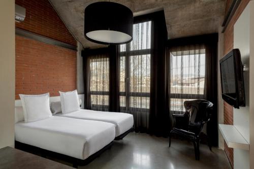 巴塞罗那巴塞罗那共和公寓酒店的一间卧室配有一张床、一把椅子和窗户。