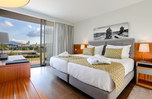 阿尔库什迪瓦尔德维什Luna Arcos Hotel Nature & Wellness的一间带大床的卧室和一个阳台