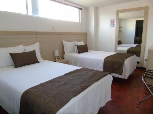 佩雷拉Hotel paradise del cafe的酒店客房,设有两张床和镜子