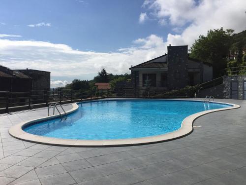 巴韦诺Armonie del Lago的一座蓝色的大型游泳池,其建筑背景为: