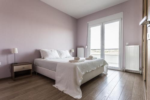 埃帕诺米Μodern apartment with big garden的白色的卧室设有床和大窗户