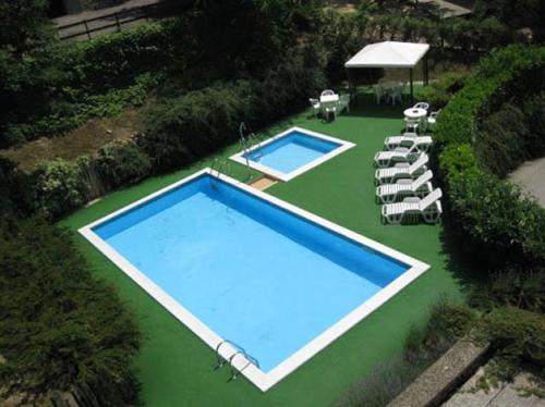 蒙泰克雷托GranChalet sul Cimone I love Montecreto 103的绿色草坪上两个游泳池的顶部景色