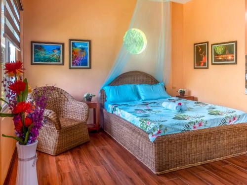 公主港Blue Moon Guesthouse的一间卧室配有一张床和两张藤椅