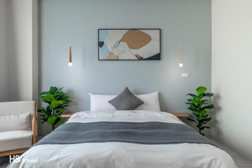 台东H& Taitung Feng Lin Resort Hotel的卧室配有一张床,墙上挂着一幅画