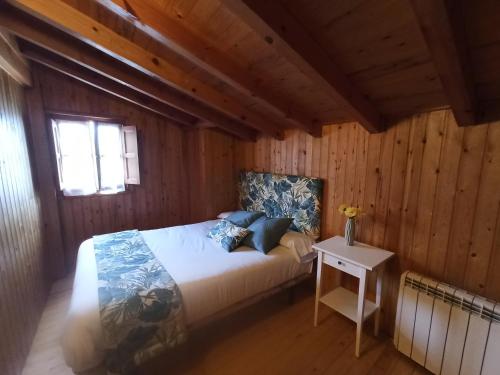 坎加斯-德奥尼斯Casa Rural La Cabaña的木制客房内的一间卧室,配有一张床