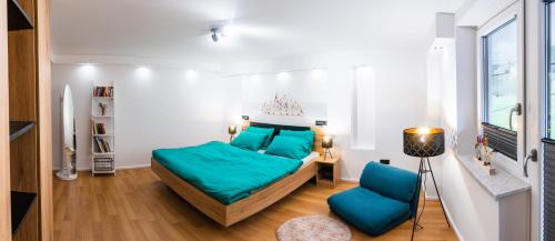 采尔克诺Zelena dolina的一间卧室配有一张带蓝色床单的床和一把椅子