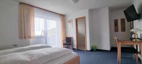 农嫩霍恩赛德酒店的一间卧室配有一张床、一张书桌和一个窗户。